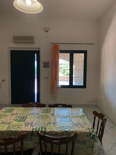 a dining room with a table and a window at Su Giardinu in Girasole