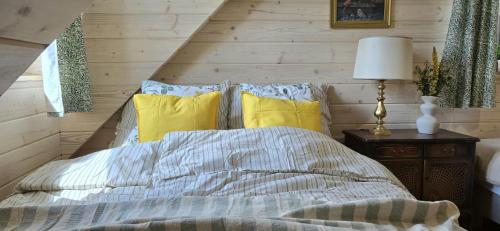 a bedroom with a bed with yellow pillows at Stacja Serwy - Dom z duszą in Serwy