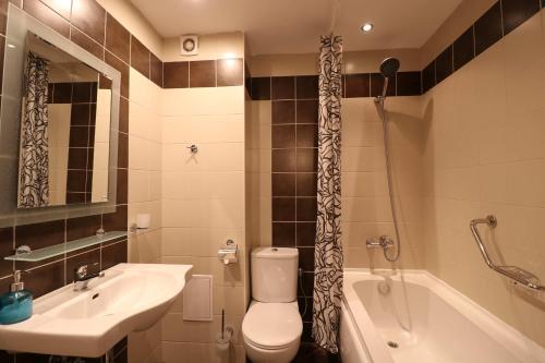 een badkamer met een wastafel, een toilet en een bad bij Първа линия Апартаменти in Pomorie