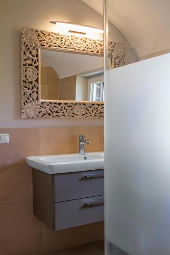 a bathroom with a sink and a mirror at Alpenhof Garnihotel & Ferienwohnungen in Garmisch-Partenkirchen