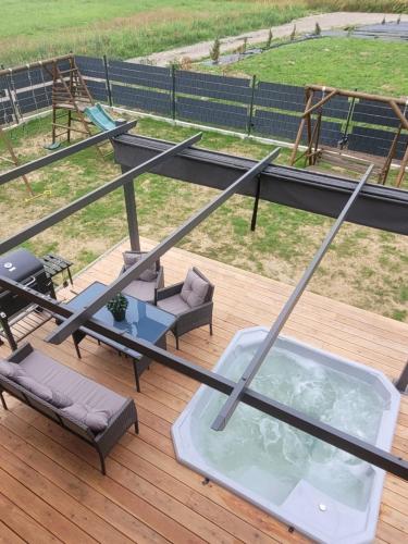 a hot tub on a deck with chairs and a table at Parkcity SPA Domek z jacuzzi w górach in Biała Niżna