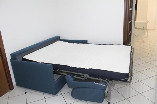 a bed sitting in a room with a chair at La casa Bianca di Luca in Fiumicino