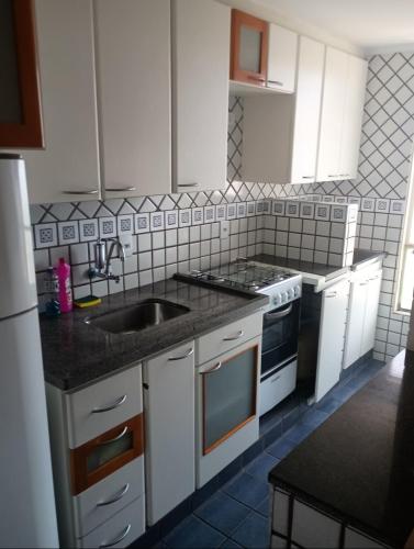 a kitchen with a sink and a stove top oven at Kitnet central in Franca