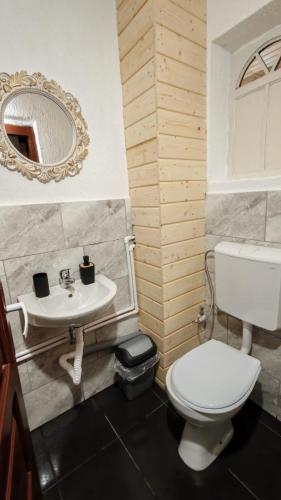 a bathroom with a white toilet and a sink at Casutadinvama in Vama Veche