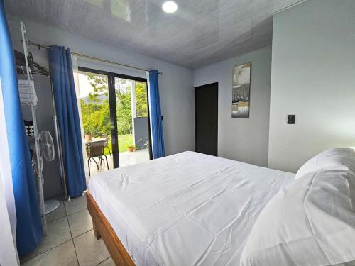 a bedroom with a bed and a large window at Casa Vista Arenal in Fortuna