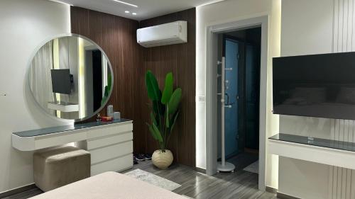 a bathroom with a sink and a mirror and a tv at Marwa Galal in Abū Rawwāsh