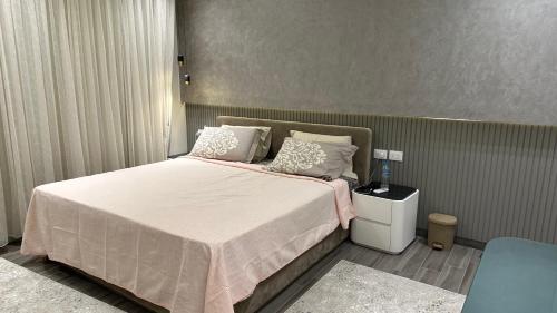 a bedroom with a large bed with white sheets and pillows at Marwa Galal in Abū Rawwāsh