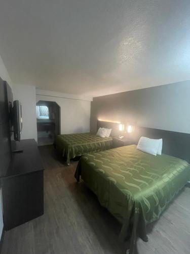 a hotel room with two beds and a television at FairBridge Inn & Suites in McDonough