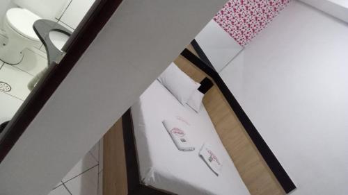 une chambre avec un lit avec une paire de pantoufles dans l'établissement Hotel Las Vegas Guarulhos, à Guarulhos