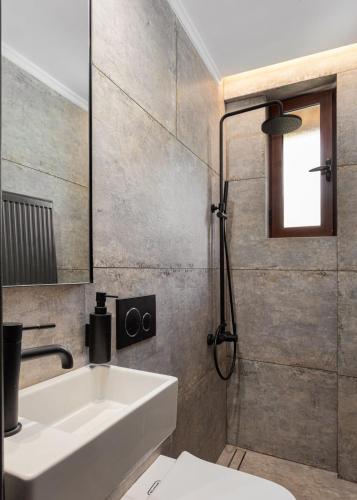 a bathroom with a white sink and a shower at Filippos by GM Luxury Suites Kalavryta in Kalavrita