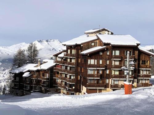 un grand bâtiment avec de la neige dessus dans l'établissement Résidence Les Soldanelles - Studio divisible 4 pers - LES SOLDANELLES - PLAGNE VILLAGES MAE-5944, à Aime La Plagne