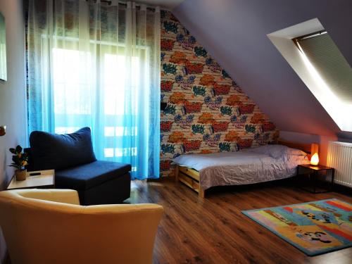 ein Schlafzimmer mit einem Bett und einem Stuhl und einem Fenster in der Unterkunft Familijne Zacisze in Mienzebrosche