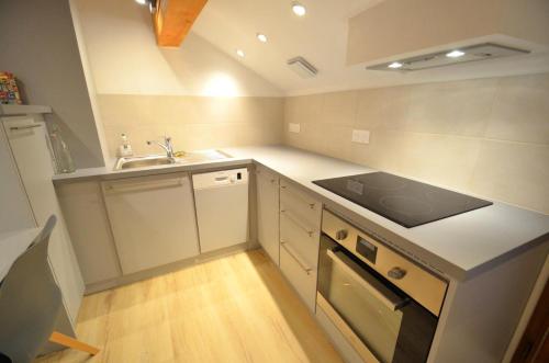 une petite cuisine avec un évier et une cuisinière dans l'établissement Chalet Barthelemy - Petit cocon authentique dans les 3 vallées MAE-4204, à Saint-Martin-de-Belleville