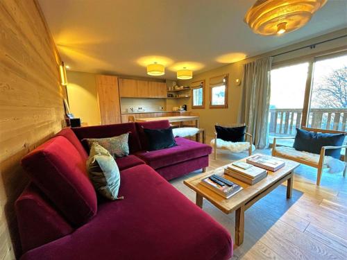 un salon avec un canapé rouge et une table dans l'établissement Les Chalets Du Cheval Noir - Appartement neuf 4 pièces 8 personnes avec vue la vallée MAE-2174, à Saint-Martin-de-Belleville
