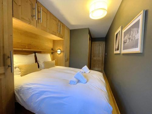 - une chambre dotée d'un grand lit avec un ours en peluche bleu dans l'établissement Les Chalets Du Cheval Noir - Appartement neuf 4 pièces 8 personnes avec vue la vallée MAE-2174, à Saint-Martin-de-Belleville