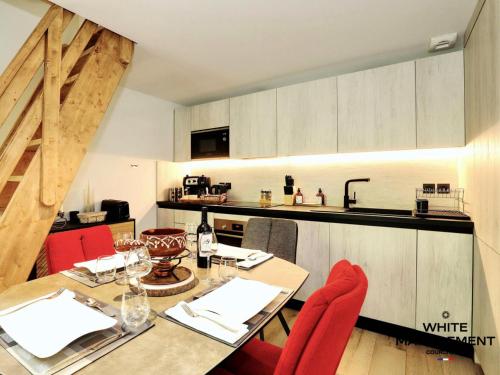 une salle à manger avec une table et des chaises rouges dans l'établissement Résidence Ariondaz Heliantheme - Penthouse intimiste avec mezzanine MAE-9074, à Courchevel