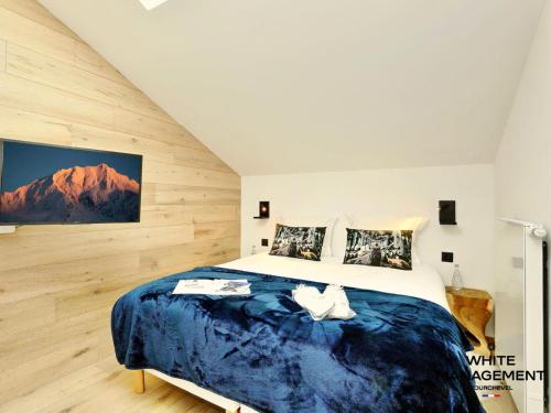 une chambre avec un grand lit avec une couverture bleue dans l'établissement Résidence Ariondaz Heliantheme - Penthouse intimiste avec mezzanine MAE-9074, à Courchevel