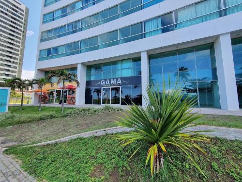 a palm tree in front of a building at Marinas da Barra - Flat Beira-Mar em Barra de Jangada por Yolo in Recife