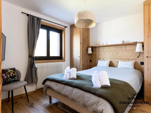 une chambre avec un lit avec des serviettes blanches dessus dans l'établissement Résidence L'ourse Bleue - Appartement familial rénové au pied des pistes MAE-8344, à Courchevel