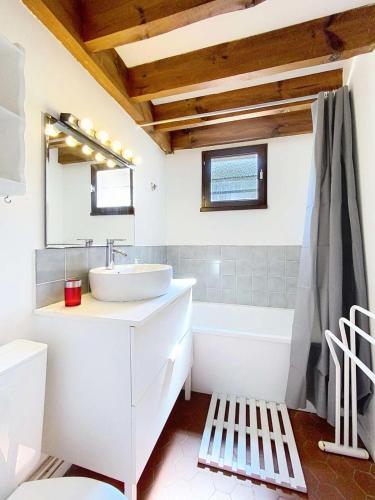 La salle de bains blanche est pourvue d'un lavabo et d'une baignoire. dans l'établissement Résidence Les As - Maisonnette 5 personnes, coté forêt à Lacanau Océan (sud) MAE-0281, à Lacanau