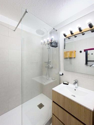 une salle de bain blanche avec un lavabo et une douche dans l'établissement Résidence Bleu Marine - Proche océan appartement 4 personnes, résidence avec piscine, Lacanau Océan MAE-7181, à Lacanau