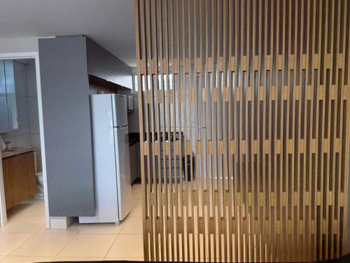 a wooden wall in a kitchen with a refrigerator at Studio Mobiliado com Vista Mar a 30m da Praia de Ponta de Campina in Cabedelo