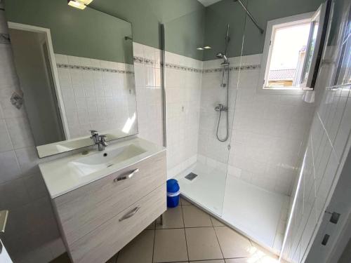 une salle de bain avec une douche, un lavabo et un miroir dans l'établissement Résidence 110-montalivet - Réf 110 - Jolie maison proche du marché de Montalivet et de ses plages MAE-7081, à Vendays-Montalivet