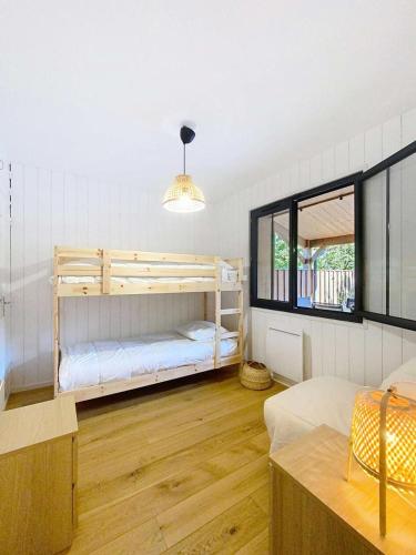 une chambre avec deux lits superposés et une fenêtre dans l'établissement Résidence 03280-lacanau - Proche du lac magnifique cottage avec piscine privée pour 7 personnes MAE-0491, à Lacanau