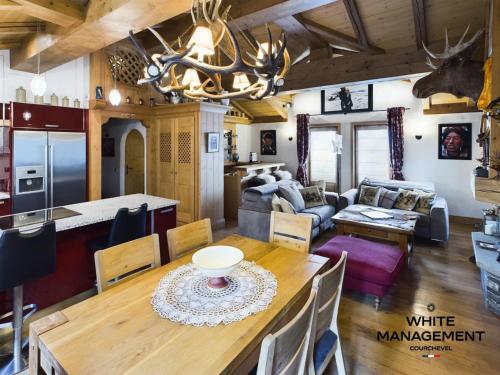 Il comprend une salle à manger et un salon avec une table et une cuisine. dans l'établissement Résidence Amadablam - Charmant appartement au coeur de Courchevel 1850 MAE-3781, à Courchevel