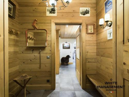 une pièce avec des murs en bois et un couloir avec un cheval à l'intérieur dans l'établissement Résidence Amadablam - Charmant appartement au coeur de Courchevel 1850 MAE-3781, à Courchevel