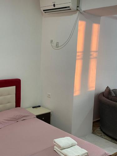 a bedroom with a bed and a chair and a window at Traceys 3 Apartments Borsh in Borsh