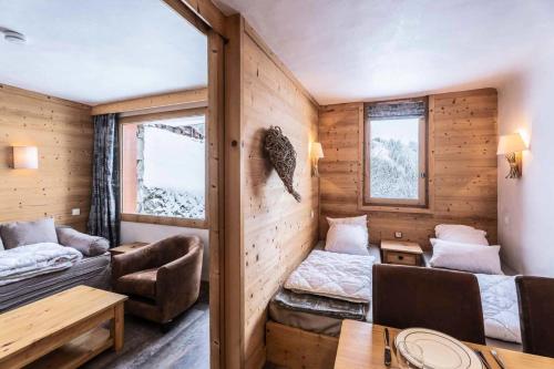 Cette chambre comprend un salon avec un lit et une table. dans l'établissement Résidence Arc En Ciel - ARC EN CIEL I03<br /> MAE-4081, à Les Allues