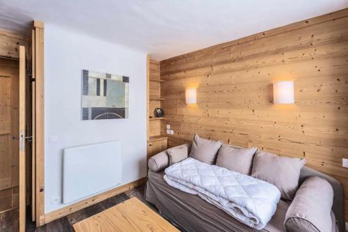 - un canapé dans une chambre dotée d'un mur en bois dans l'établissement Résidence Arc En Ciel - ARC EN CIEL I03<br /> MAE-4081, à Les Allues