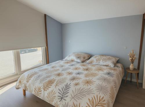 a bedroom with a bed in a room with a window at Grange Les Sens Ciel in Saint-Mesmin