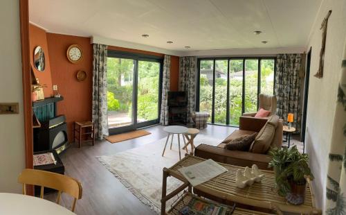 a living room with a couch and a table at Relax Chalet Veluwe in Putten