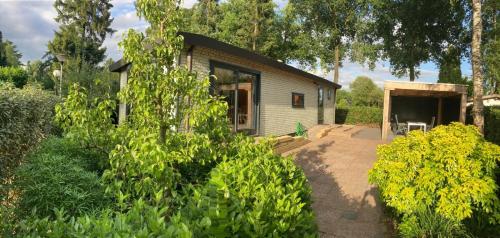 a small house with a patio in front of it at Relax Chalet Veluwe in Putten