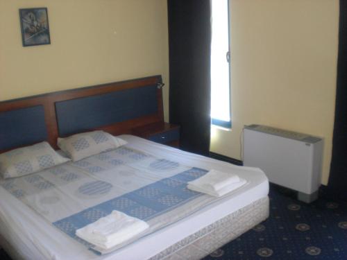 a bedroom with a bed with two towels on it at Fenix Family Hotel in Blagoevgrad