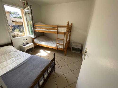une chambre avec deux lits superposés et une fenêtre dans l'établissement Résidence 110-montalivet - Réf 110 - Jolie maison proche du marché de Montalivet et de ses plages MAE-7081, à Vendays-Montalivet