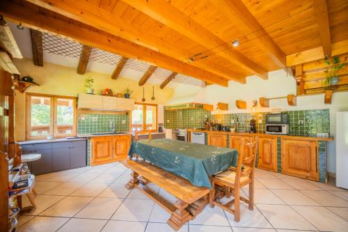 a large kitchen with wooden cabinets and a table at le vorger in Villard-sur-Doron