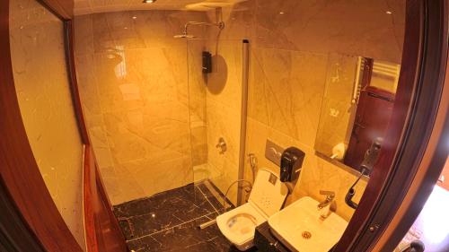 a bathroom with a shower and a toilet and a sink at Meric Hotel in Uzungöl