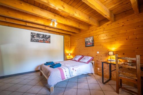 a bedroom with a bed in a wooden cabin at le vorger in Villard-sur-Doron