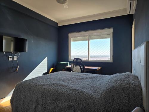 a blue bedroom with a bed and a window at APTO 1004 Ed PEQUENO PRÍNCIPE in Uruguaiana