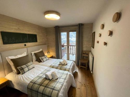 une chambre avec deux lits et un balcon dans l'établissement Les Chalets Du Gypse - LES CHALETS DU GYPSE C14 MAE-3671, à Saint-Martin-de-Belleville