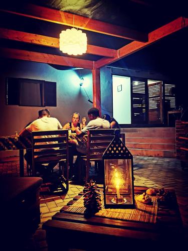 a group of people sitting at a table in a restaurant at Kaza Ladera in Seladinha