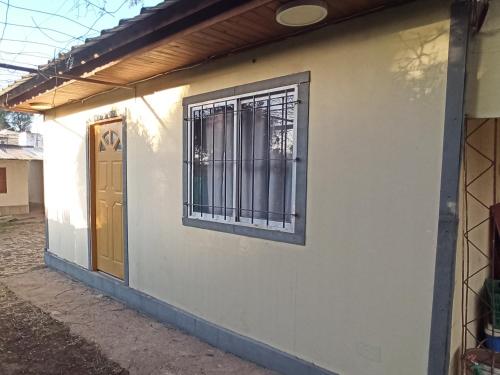 a building with a barred window and a door at Complejo Corrientes Dpto 3 in Jesús María