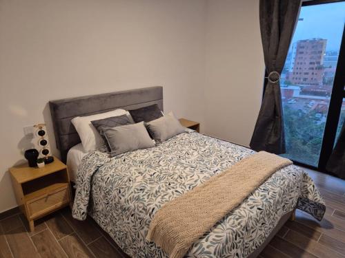 a bedroom with a bed and a large window at Parque14, Ciudad Guatemala, Aeropuerto La Aurora in Estación Pamplona