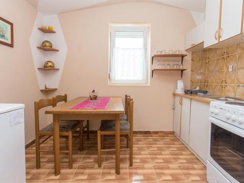 a small kitchen with a wooden table and chairs at Villa Valentina in Zadar