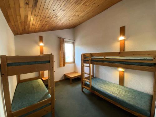 une chambre avec trois lits superposés et une fenêtre dans l'établissement Résidence Portail G - PORTAIL 72 MAE-6391, à Valmorel