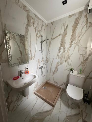 a bathroom with a sink and a toilet at Beach House - Ramsis Village in ‘Izbat aţ Ţayrīyah