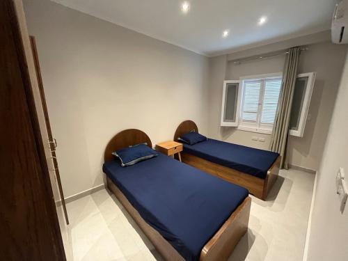 a bedroom with two beds and a window at Beach House - Ramsis Village in ‘Izbat aţ Ţayrīyah